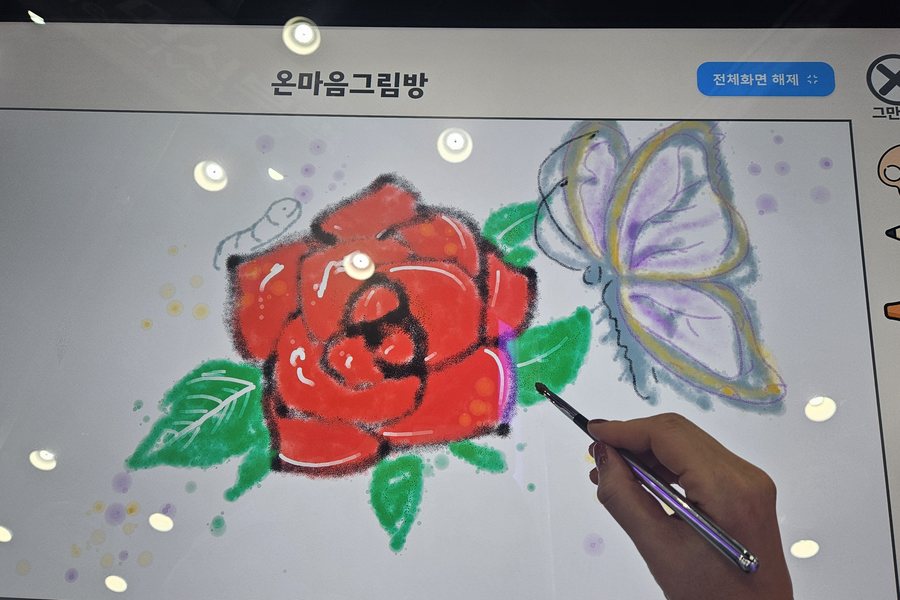 하트 캔버스에 장미를 그리는 손